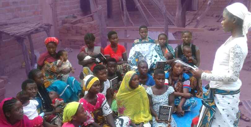 A group of first-time mothers in their support group listen to a peer educator